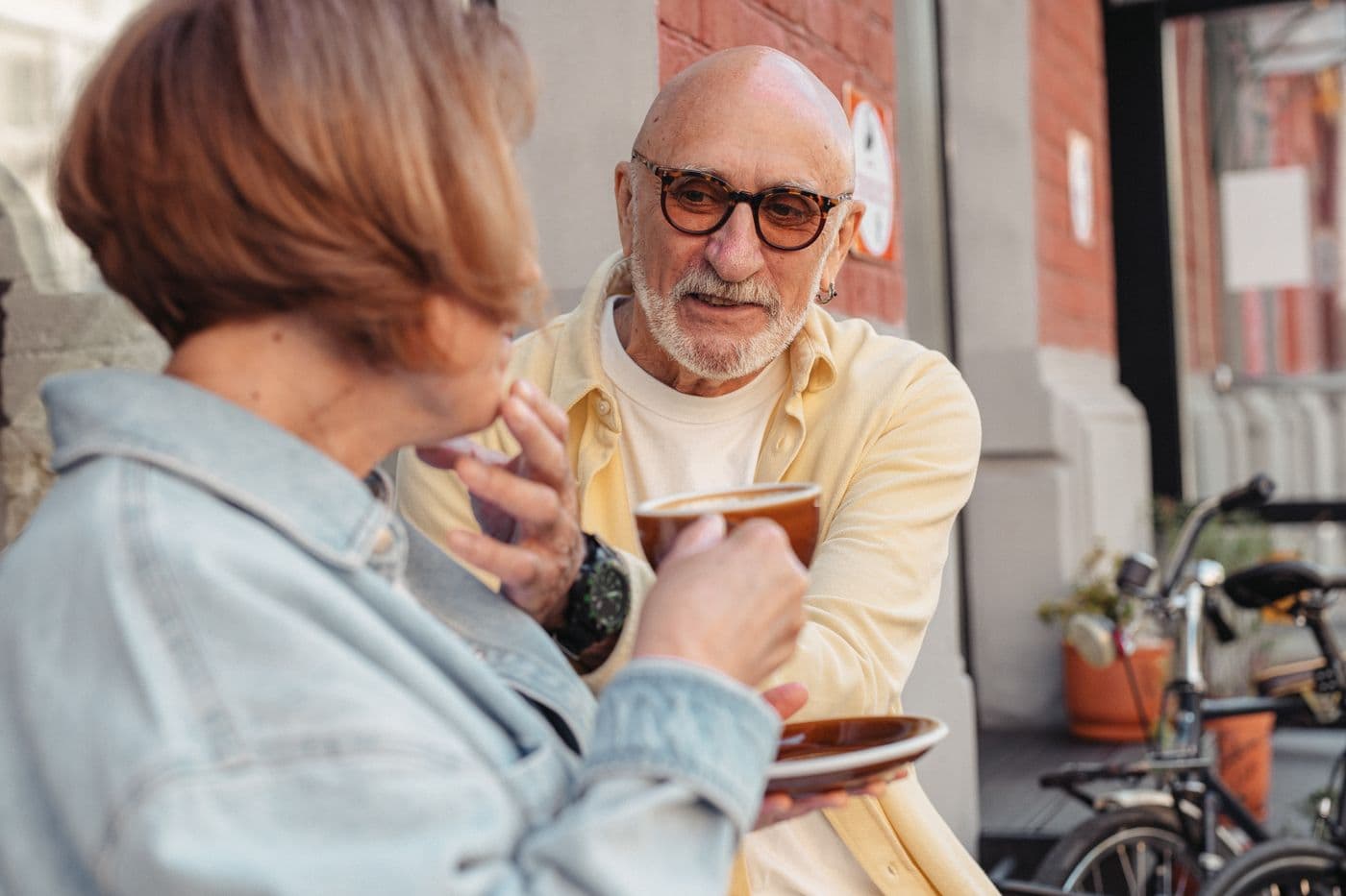 A couple laughing over coffee at an outdoor café